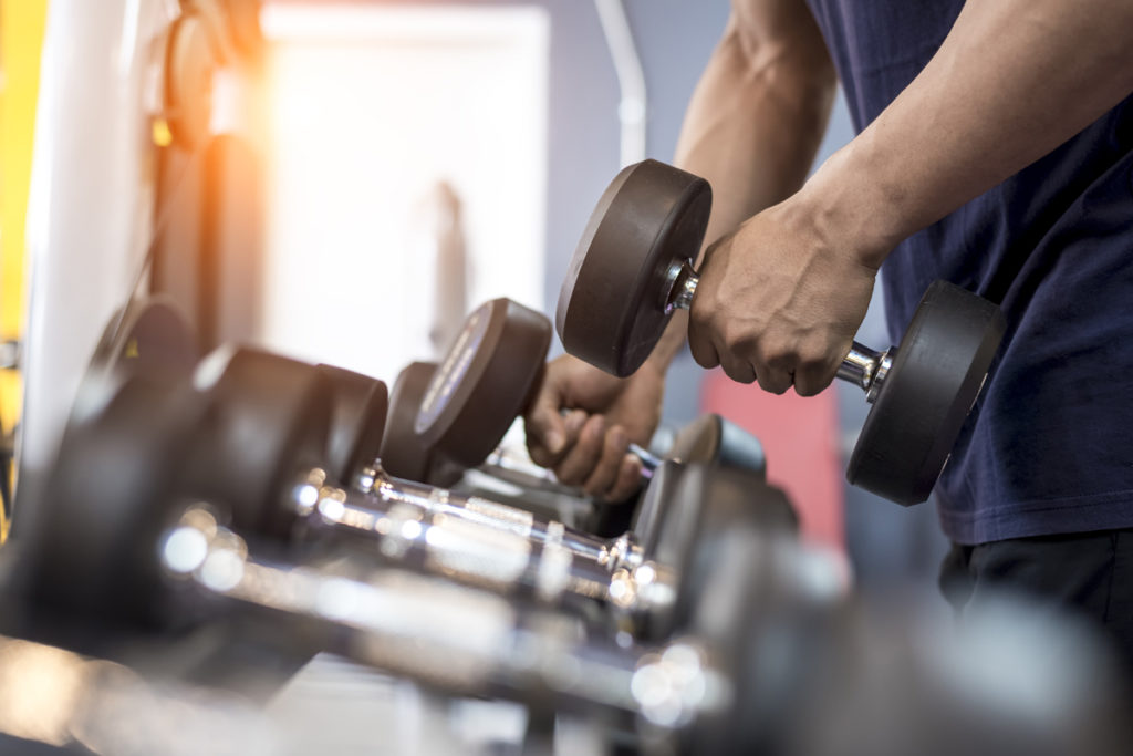 Person lifting dumbbell off of a rack